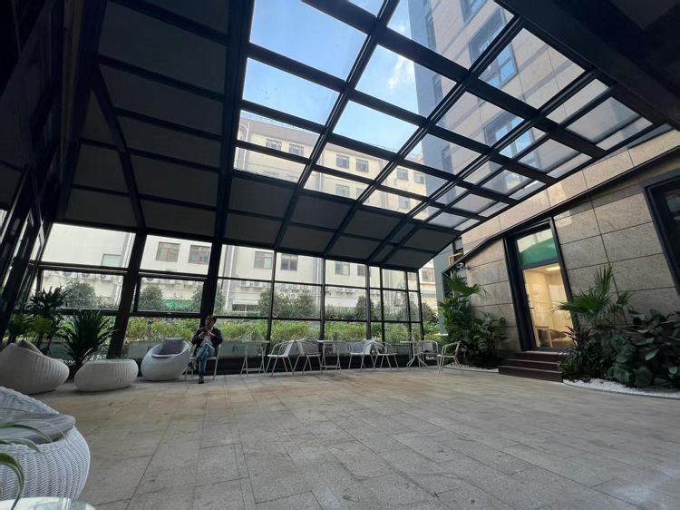 Sunroom tal-ħġieġ mgħawweġ bis-saqaf li jista 'jinġibed lura